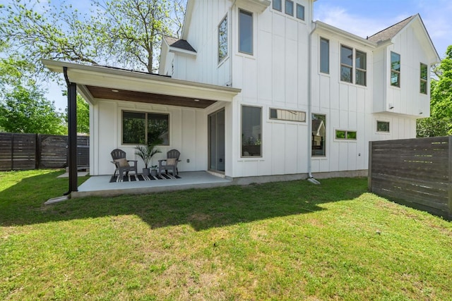 rear view of property with board and batten siding and a patio area