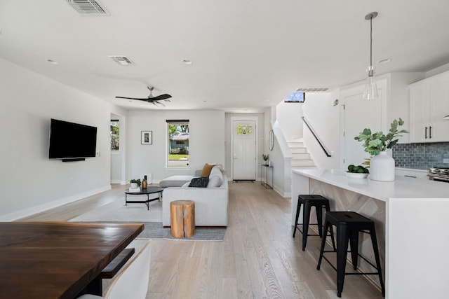 4502 Banister Ln Unit 1, Austin, TX 78745 - living area with light wood finished floors, recessed lighting, ceiling fan, stairway, and baseboards