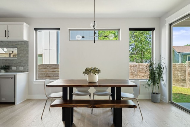 dining room featuring light wood finished floors and baseboards