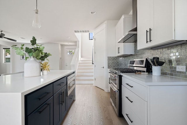 kitchen with stainless steel appliances, light wood-type flooring, backsplash, light countertops, and recessed lighting