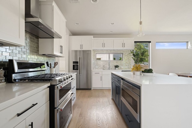 4502 Banister Ln Unit 1, Austin, TX 78745 - kitchen featuring appliances with stainless steel finishes, wall chimney exhaust hood, white cabinets, light countertops, and recessed lighting