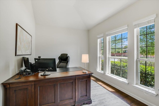 home office featuring wood finished floors, baseboards, and vaulted ceiling