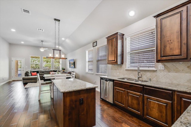 kitchen with ceiling fan, visible vents, a kitchen island, dishwasher, and a sink