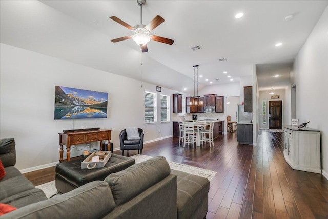 living area featuring visible vents, baseboards, a ceiling fan, dark wood-style floors, and vaulted ceiling