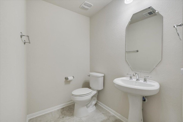 half bathroom featuring tile patterned flooring, visible vents, baseboards, and toilet