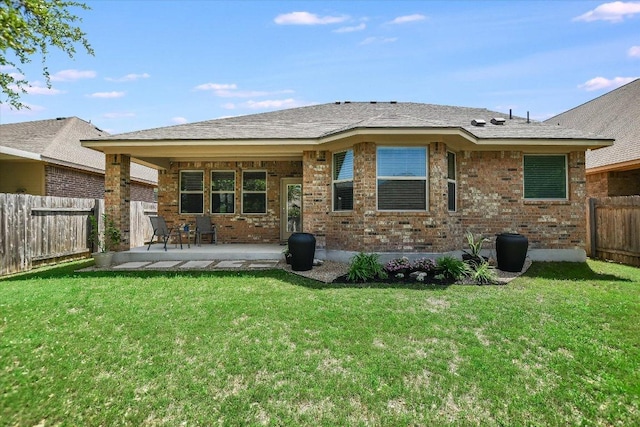 rear view of property with a patio area, a fenced backyard, brick siding, and a yard