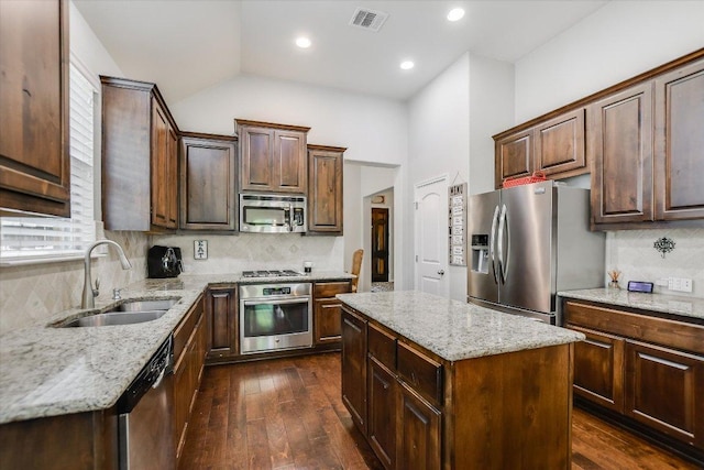 kitchen with visible vents, appliances with stainless steel finishes, light stone counters, a sink, and backsplash