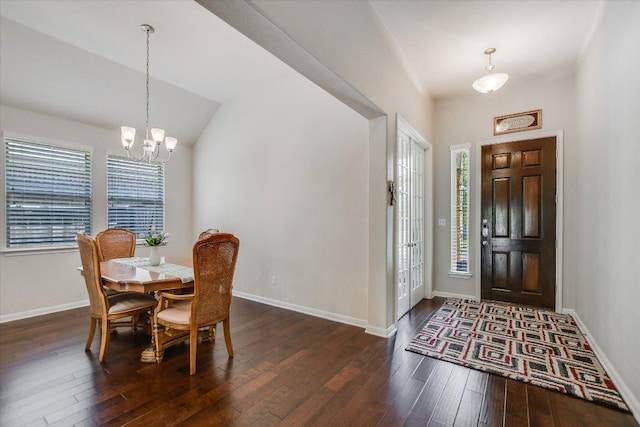foyer entrance with hardwood / wood-style floors, an inviting chandelier, baseboards, and lofted ceiling