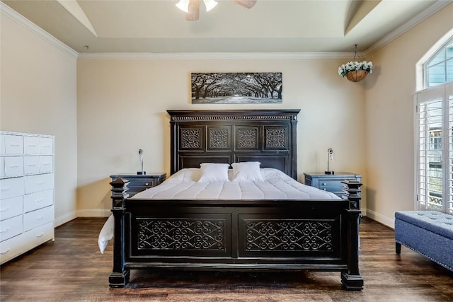 bedroom featuring dark wood finished floors, baseboards, and a raised ceiling