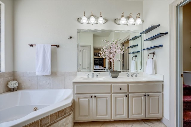bathroom featuring double vanity, a jetted tub, and a sink