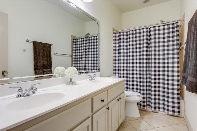 full bath with a sink, tile patterned flooring, toilet, and double vanity
