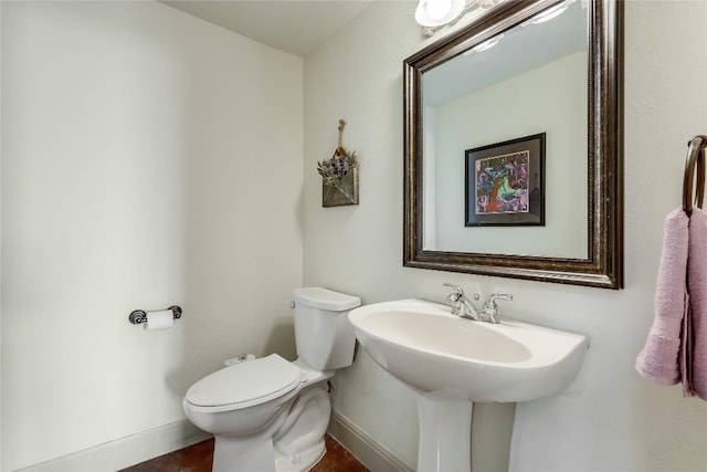 half bath with toilet and baseboards