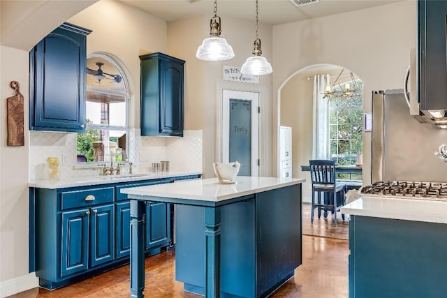 21735 Sierra Trl, Lago Vista, TX 78645 - kitchen with blue cabinetry, decorative backsplash, a center island, arched walkways, and light countertops
