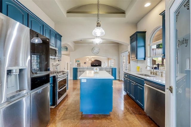 21735 Sierra Trl, Lago Vista, TX 78645 - kitchen featuring blue cabinetry, appliances with stainless steel finishes, a raised ceiling, a center island, and arched walkways