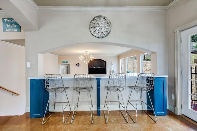 21735 Sierra Trl, Lago Vista, TX 78645 - kitchen with blue cabinets, crown molding, arched walkways, and a kitchen breakfast bar