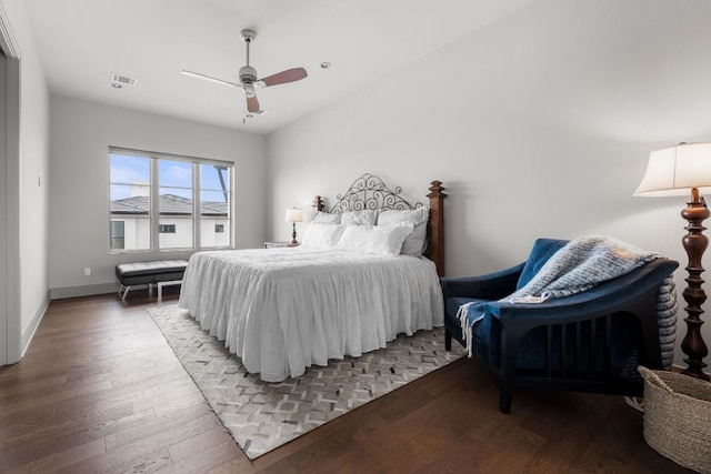 bedroom featuring baseboards, wood finished floors, visible vents, and a ceiling fan