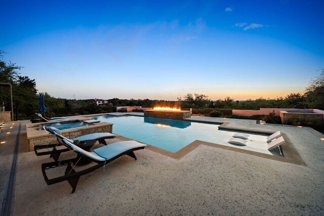 view of swimming pool featuring an outdoor fire pit, a patio, and a pool with connected hot tub