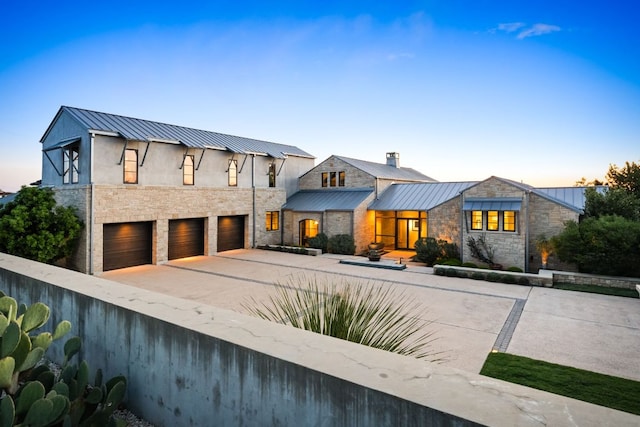 modern home featuring stone siding, a standing seam roof, and metal roof