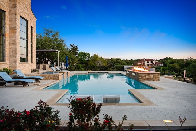 view of pool with a fire pit, a patio area, and a pool with connected hot tub