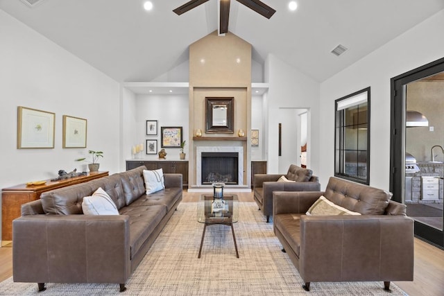 4010 County Road 404, Spicewood, TX 78669 - living area featuring light wood-style flooring, beamed ceiling, a fireplace, a ceiling fan, and high vaulted ceiling