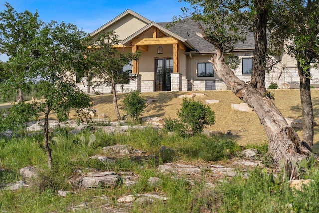 4010 County Road 404, Spicewood, TX 78669 - view of front facade featuring stucco siding, stone siding, a shingled roof, and french doors