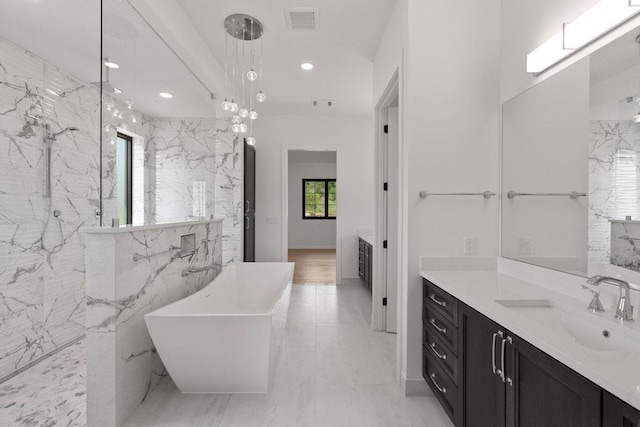 4010 County Road 404, Spicewood, TX 78669 - bathroom featuring a soaking tub, vanity, a marble finish shower, recessed lighting, and tile walls