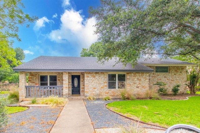 2400 Braemar Cv, Austin, TX 78747 - ranch-style house featuring stone siding, a porch, a front lawn, and roof with shingles