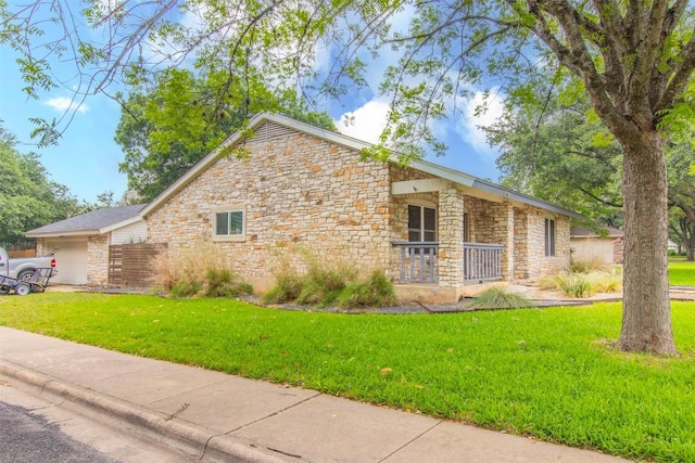 2400 Braemar Cv, Austin, TX 78747 - view of side of home with stone siding, a porch, and a lawn