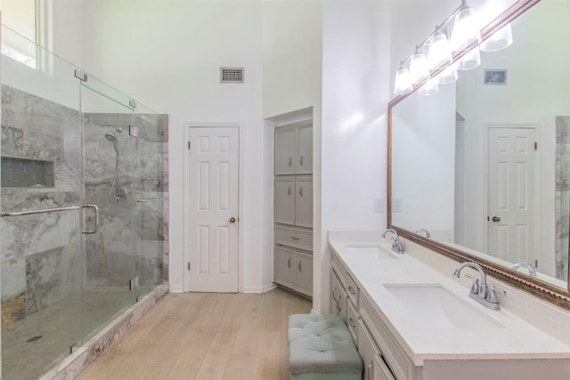 2400 Braemar Cv, Austin, TX 78747 - full bath with wood finished floors, a high ceiling, double vanity, and a stall shower