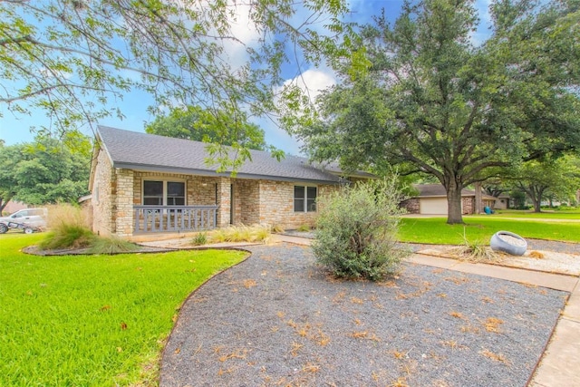 2400 Braemar Cv, Austin, TX 78747 - view of front of home with covered porch, stone siding, a front yard, and roof with shingles