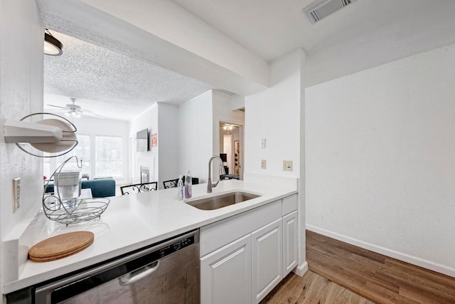 kitchen with light wood-type flooring, visible vents, ceiling fan, stainless steel dishwasher, and a sink
