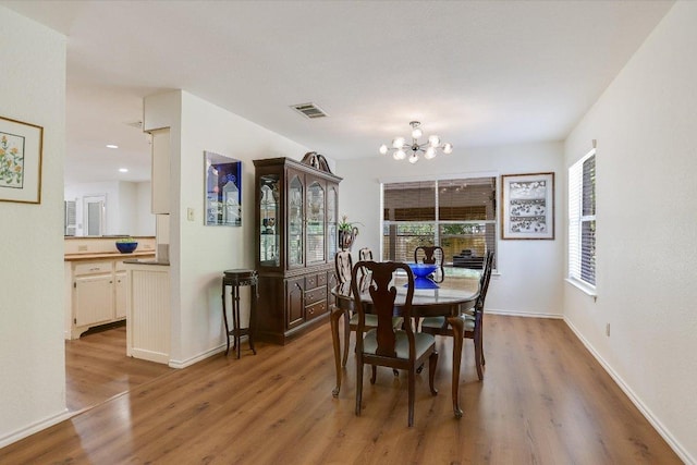 7809 Taranto Dr, Austin, TX 78729 - dining space with a chandelier, wood finished floors, healthy amount of natural light, and baseboards