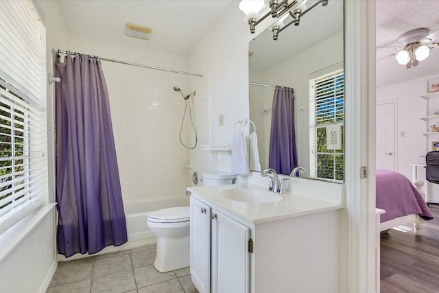 7809 Taranto Dr, Austin, TX 78729 - bathroom with vanity, shower / bathtub combination with curtain, toilet, tile patterned floors, and ceiling fan
