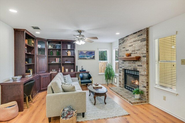 7809 Taranto Dr, Austin, TX 78729 - living room featuring ceiling fan, light wood finished floors, a fireplace, and recessed lighting