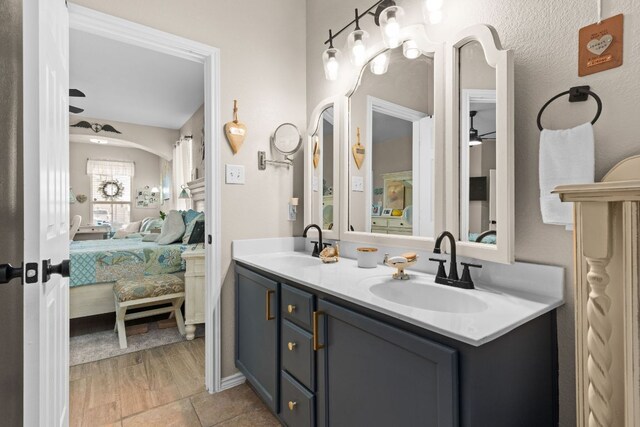full bath featuring a sink, tile patterned flooring, double vanity, and ensuite bath