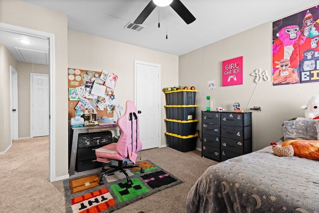 carpeted bedroom with visible vents, baseboards, attic access, and ceiling fan
