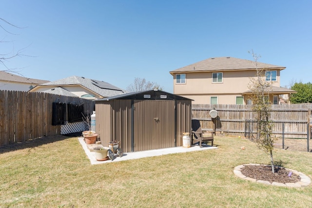 rear view of house featuring a storage shed, a yard, a fenced backyard, an outdoor structure, and stucco siding