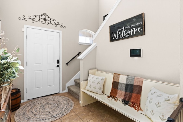 foyer with stairs, a high ceiling, and tile patterned flooring