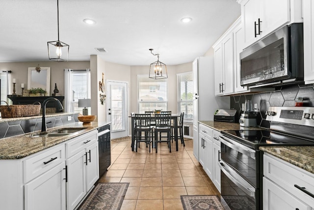 kitchen featuring tasteful backsplash, white cabinets, a sink, recessed lighting, and stainless steel appliances