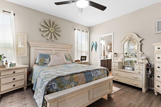 bedroom featuring a ceiling fan, ensuite bath, and dark wood finished floors