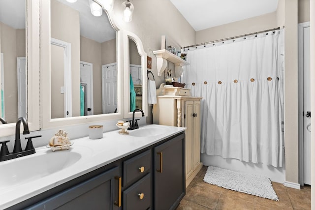 full bathroom featuring double vanity, a sink, and tile patterned flooring