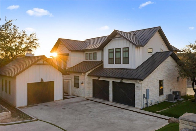 821 S Angel Light Dr, Spicewood, TX 78669 - modern farmhouse featuring a standing seam roof, stone siding, and driveway