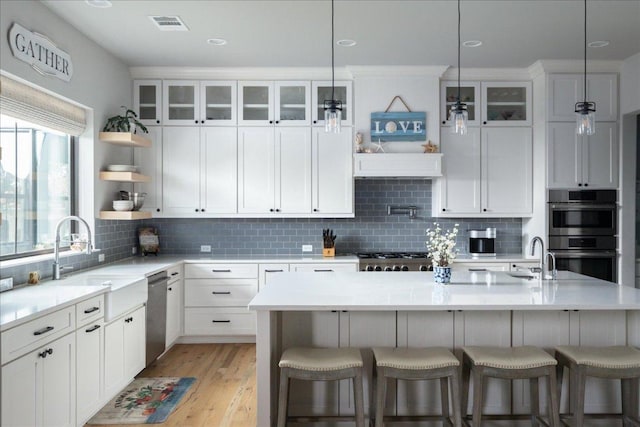 821 S Angel Light Dr, Spicewood, TX 78669 - kitchen featuring a sink, stainless steel appliances, open shelves, and a breakfast bar area
