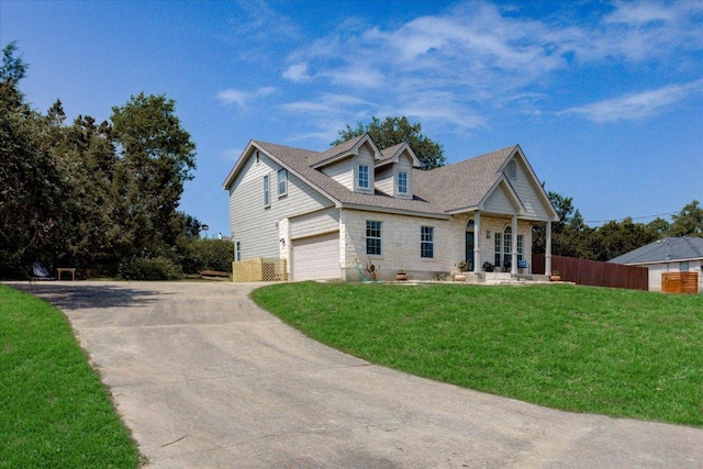 cape cod home featuring concrete driveway, an attached garage, fence, and a front lawn