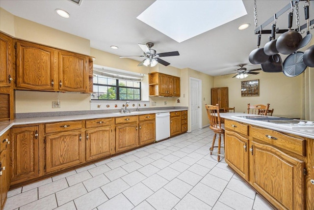 59 Fairview Dr, Round Rock, TX 78665 - kitchen featuring dishwasher, a ceiling fan, a skylight, brown cabinets, and recessed lighting