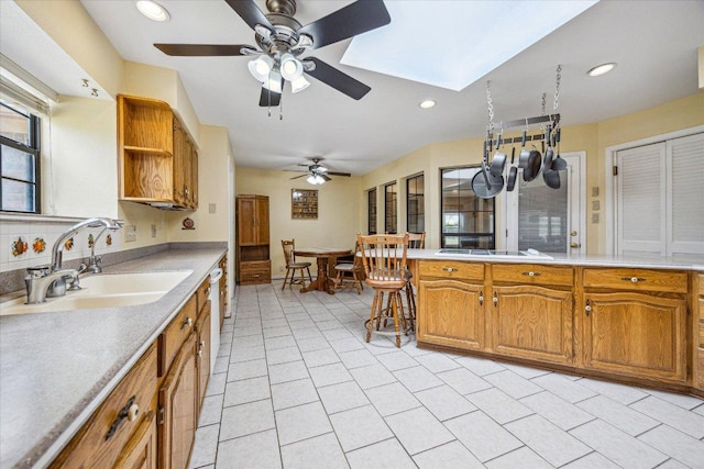 59 Fairview Dr, Round Rock, TX 78665 - kitchen featuring a ceiling fan, light countertops, open shelves, recessed lighting, and a skylight