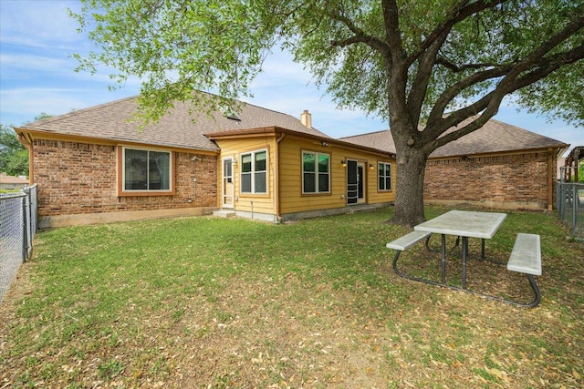 59 Fairview Dr, Round Rock, TX 78665 - back of house with a fenced backyard, roof with shingles, brick siding, and a chimney