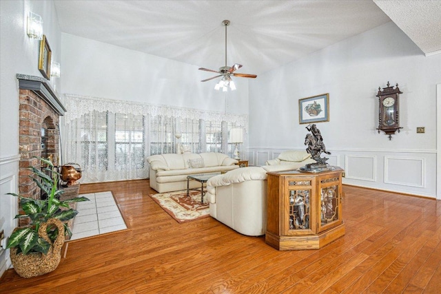 59 Fairview Dr, Round Rock, TX 78665 - living room with wood finished floors, a ceiling fan, a wainscoted wall, a brick fireplace, and a decorative wall