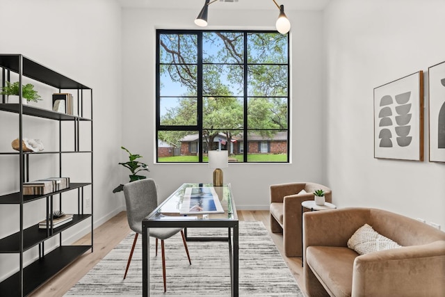 home office with light wood-type flooring and baseboards