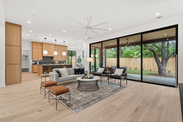 living area with recessed lighting, light wood-style floors, visible vents, and a ceiling fan